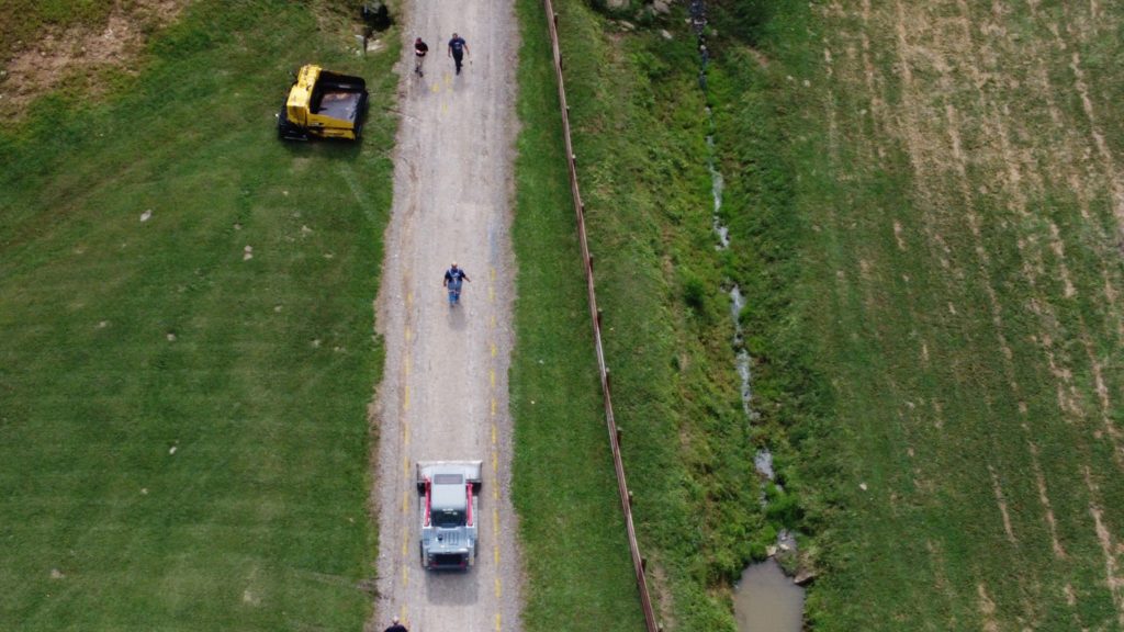 Aerial View of Crew Members Painting Guide Lines on a Farm Lane for Paving